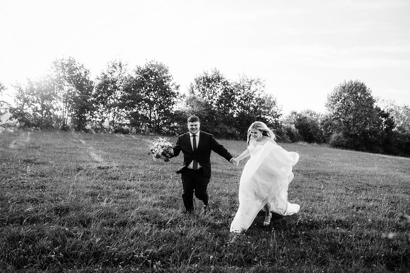 Novomanželé běží loukou, černobílá fotografie